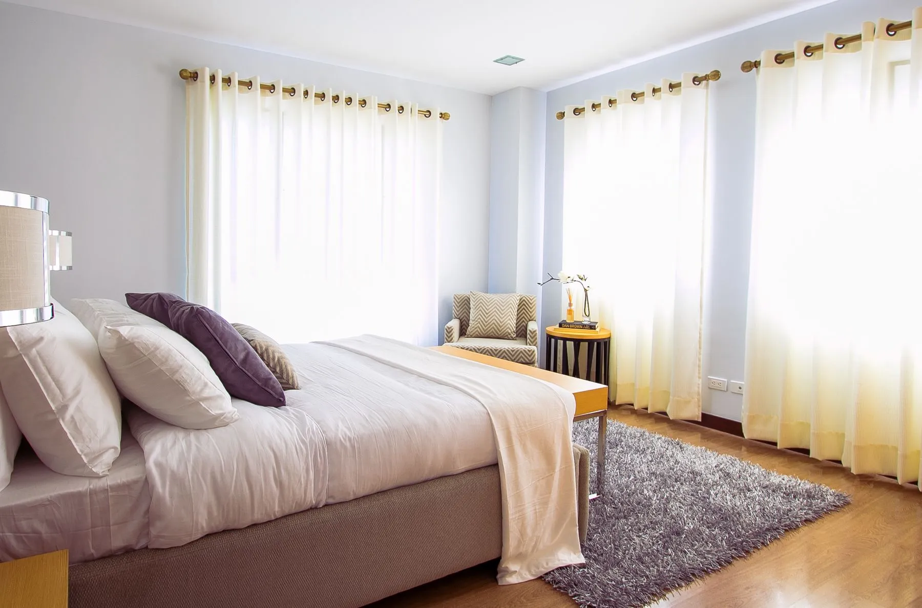 Una camera luminosa con il letto preparato e tende chiare