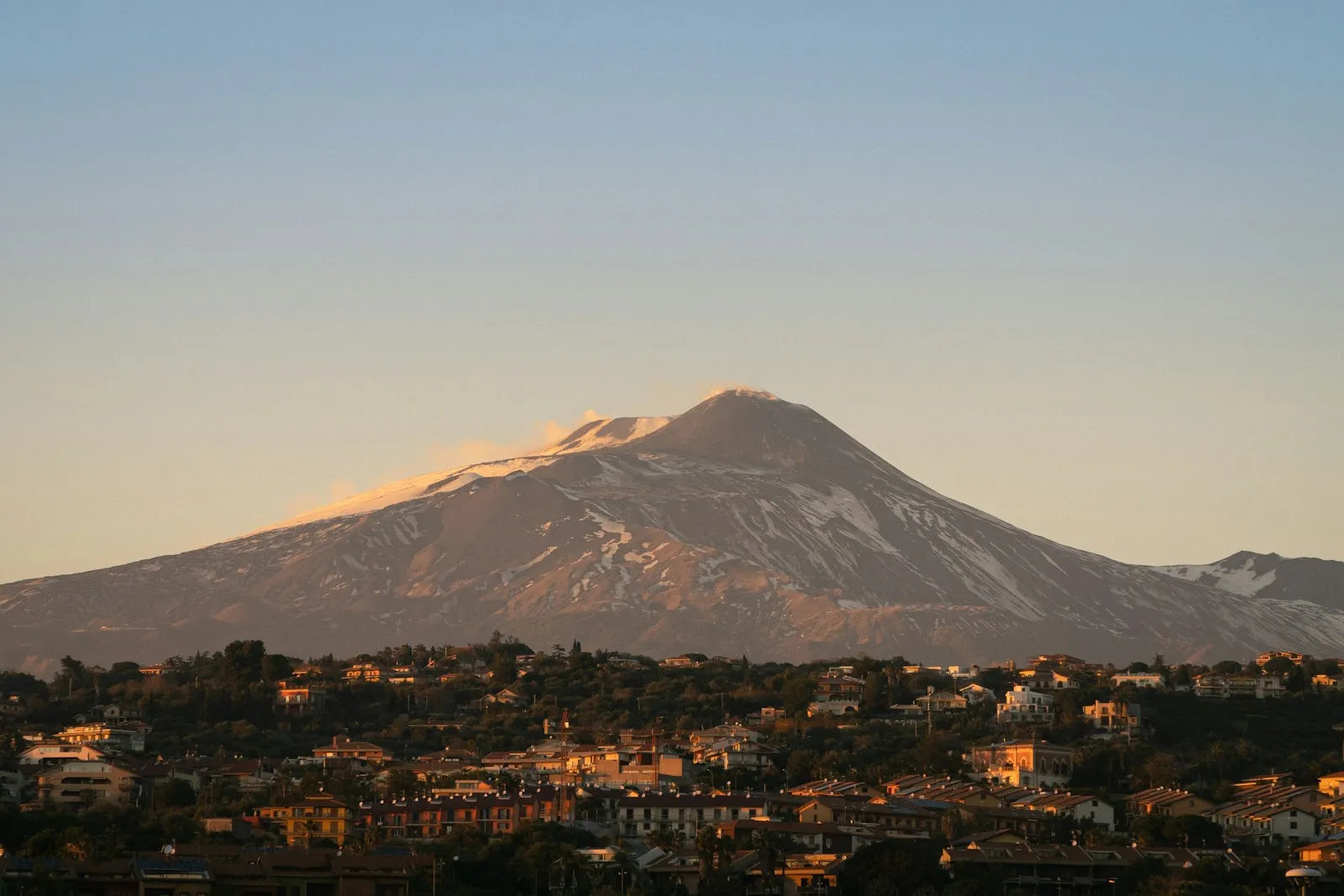 L’Etna illuminata dalla luce calda sopra i paesi etnei